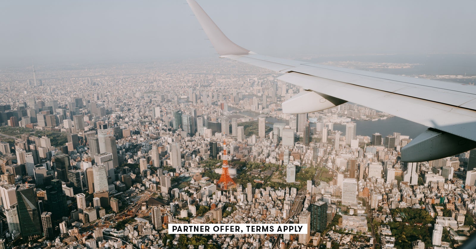 1753702704 SOCIAL IMAGE PARTNER OFFER TERMS APPLY Tokyo skyline with Tokyo Tower from airplane window Ippei Nao