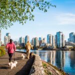 People walking dogs along Stanley Park on the Seawall Water Walk in Vancouver Canada David Hanson.jp