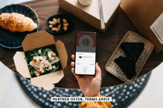 SOCIAL IMAGE PARTNER OFFER TERMS APPLY womans hand holding smartphone with takeaway food ordering mo