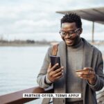 SOCIAL IMAGE PARTNER OFFERS TERMS APPLY businessman standing on street and using smart phone and ban
