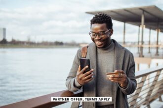 SOCIAL IMAGE PARTNER OFFERS TERMS APPLY businessman standing on street and using smart phone and ban