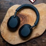 Sony WH 1000XM5 headphones laying flat on wooden table