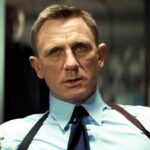 daniel craig as james bond looking annoyed while sitting in spectre