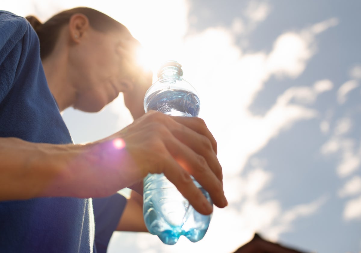 woman under hot sun holding bottle