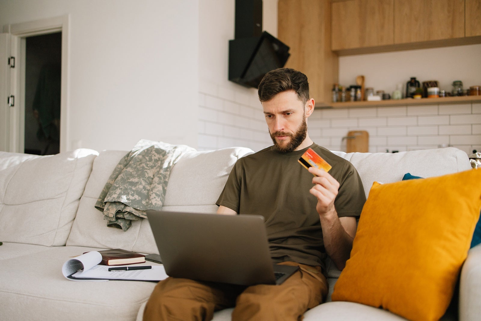 Active duty military member using laptop and credit card at home Nazar Rybak