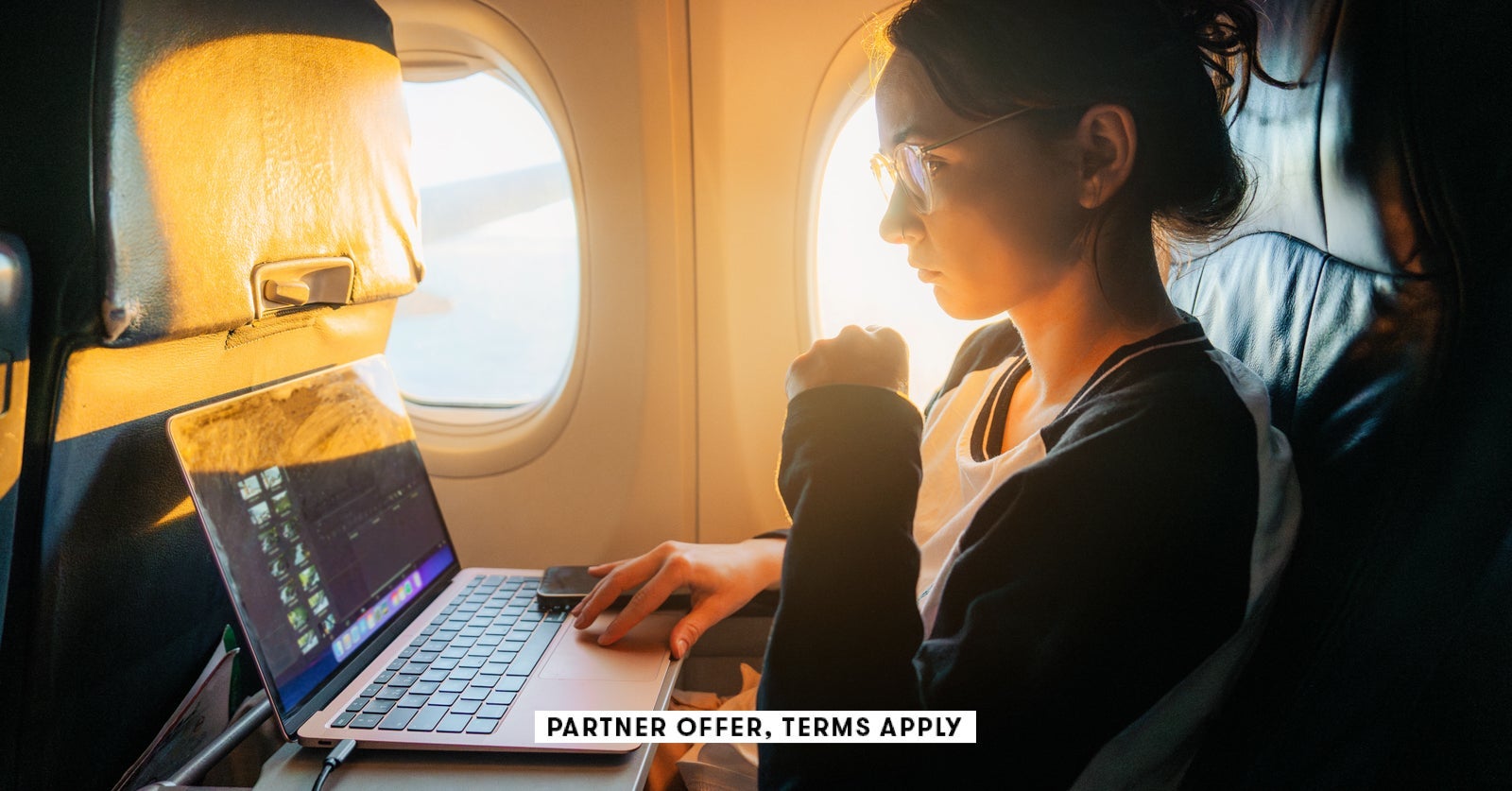 SOCIAL IMAGE PARTNER OFFER TERMS APPLY Woman working with laptop in the airplane Oleh Slobodeniuk 24