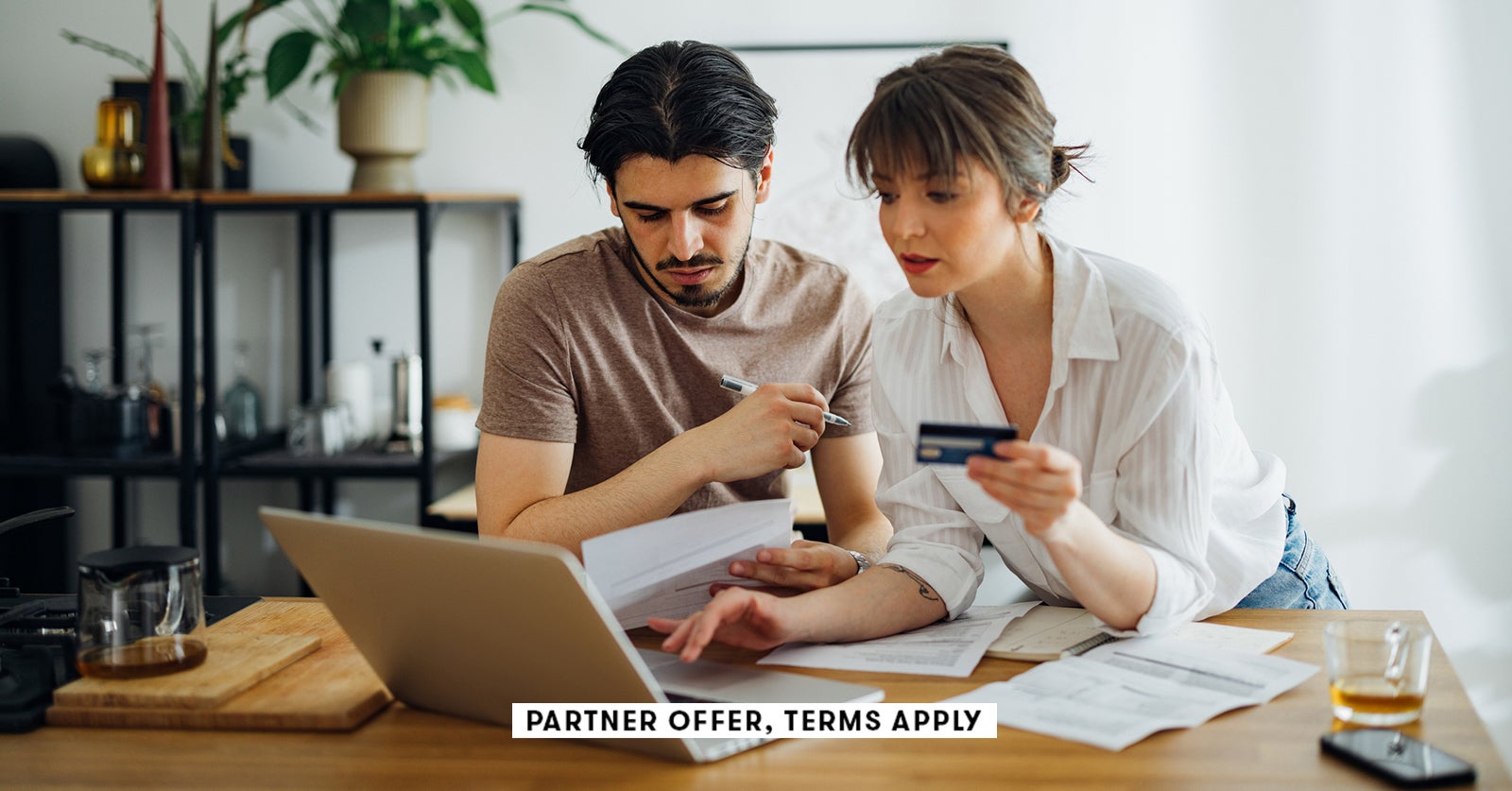 20250715 SOCIAL DISCLAIMER PARTER OFFER TERMS APPLY Couple paying bils at home with credit card mini