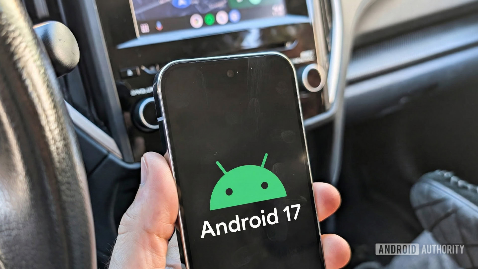 Android 17 logo on a Pixel phone held in a car 2