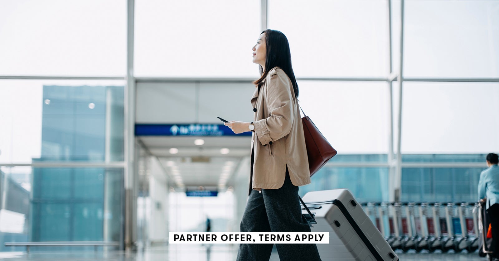 Young womanc walking throught airport with suitcase d3sign SOCIAL