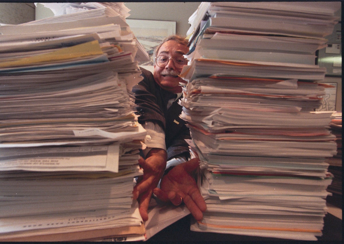 Man between paper stacks