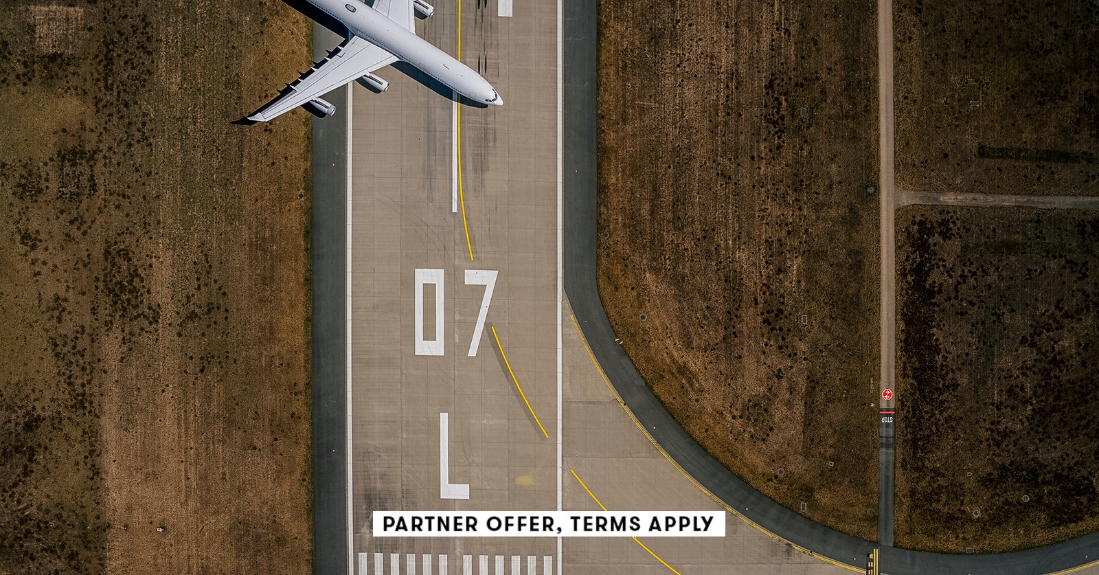 20250715 SOCIAL DISCLAIMER PARTER OFFER TERMS APPLY Birds eye view of airplane parked on airport run
