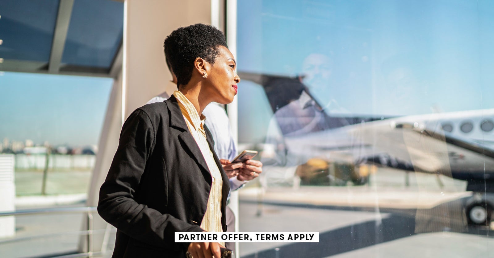 SOCIAL IMAGE PARTNER OFFER TERMS APPLY ooking through the window and using smartphone in the airport