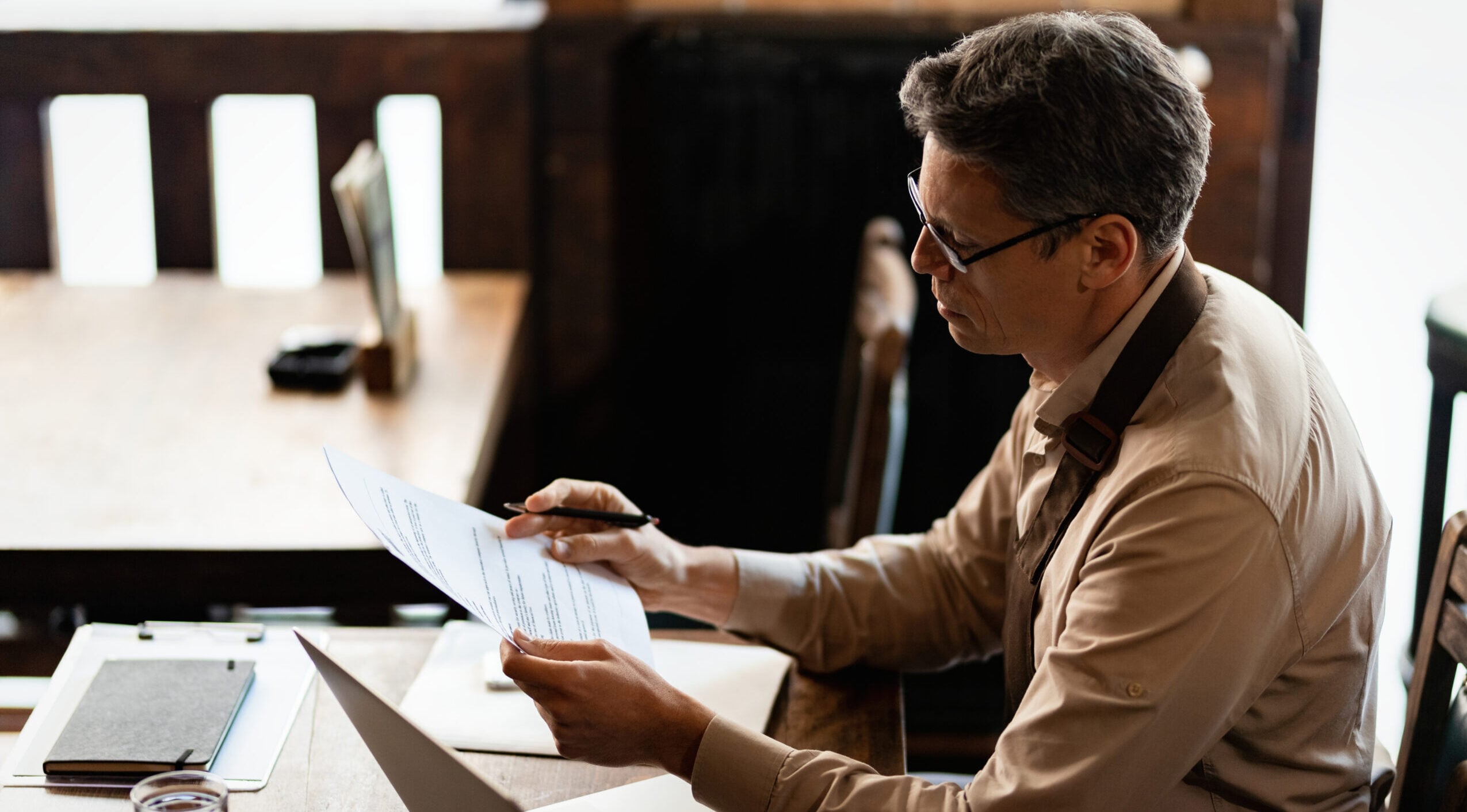 mid adult small business owner analyzing reports while working paperwork pub 1 scaled e1777412769273