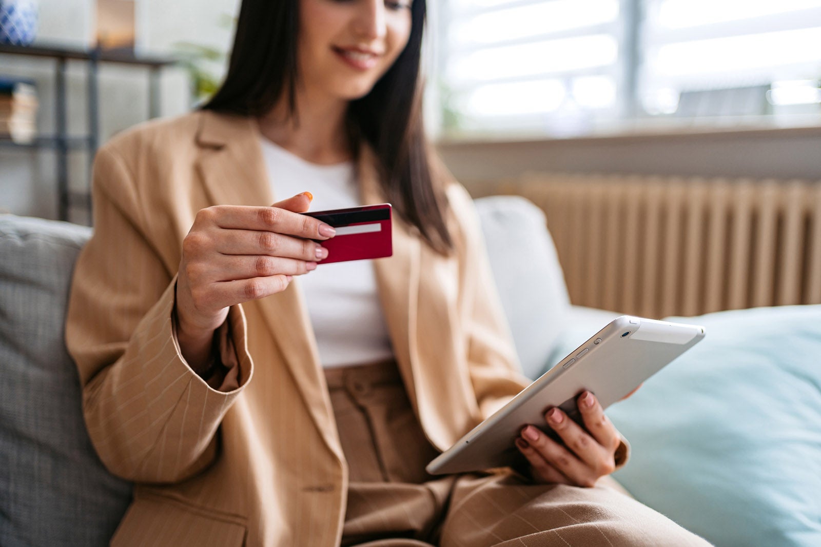 Person shopping using tablet and credit card at home urbazon