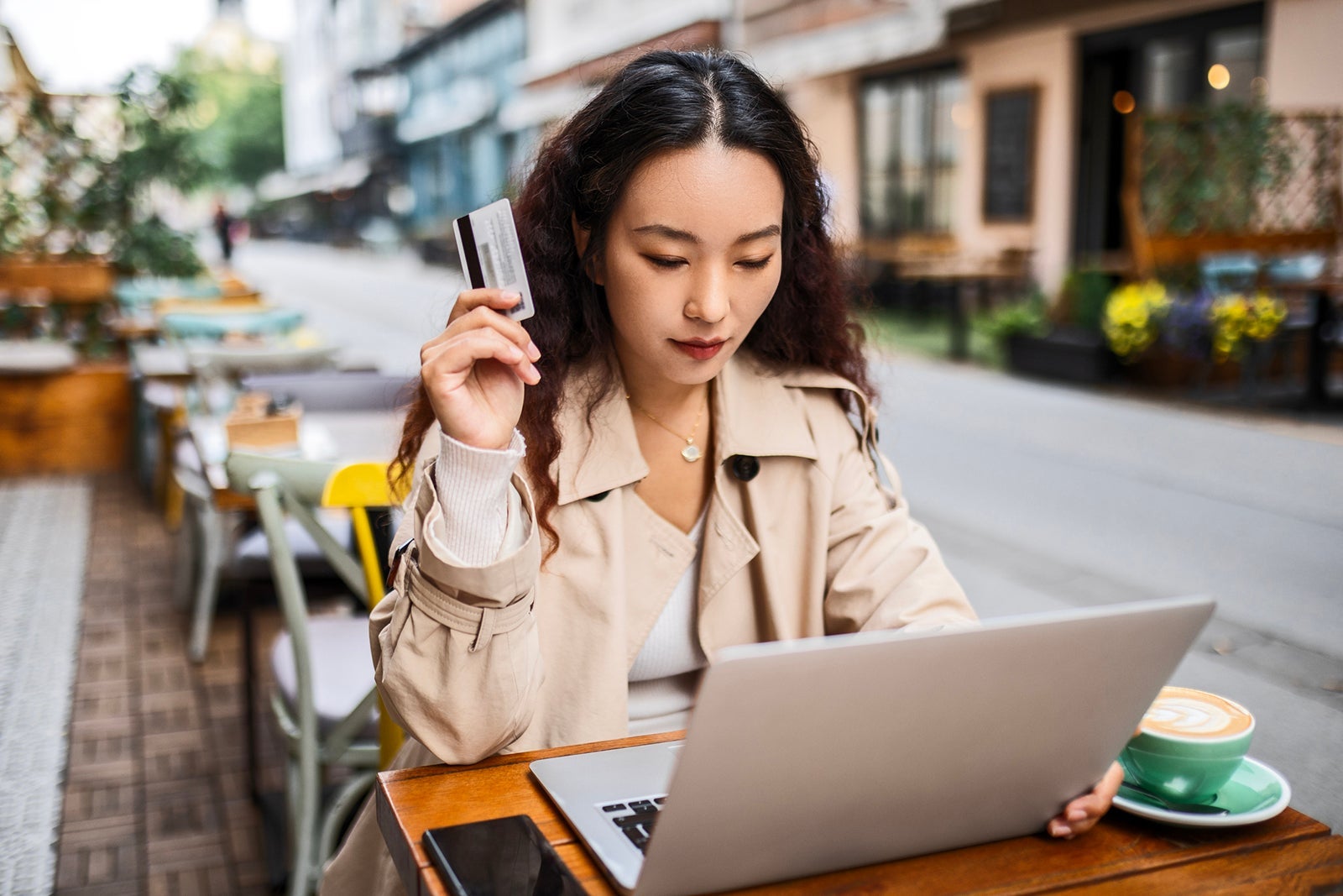 Woman in cafe using credit card while on laptop Nastasic